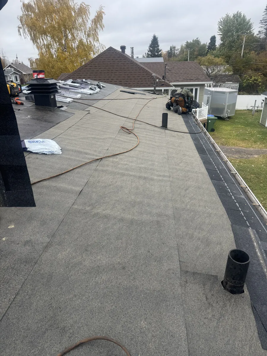 Membrane autocollante installée sur le toit, avec la pose de la nouvelle couverture en cours.